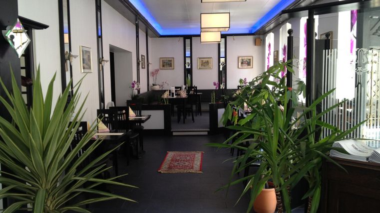 Ein stilvolles Restaurant mit moderner Einrichtung und Pflanzen. Die Beleuchtung schafft eine einladende Atmosphäre.