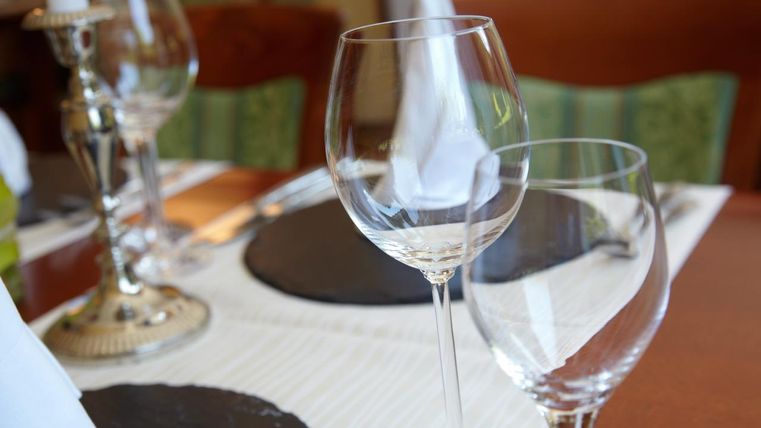 Ein elegant gedeckter Tisch mit Weingläsern und einem Kerzenhalter. Das Setting ist einladend und stilvoll.