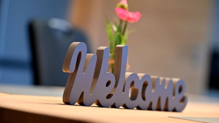 A table with a "Welcome" sign and a small flower. The atmosphere is inviting and friendly.
