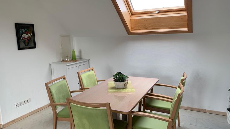 Een heldere, uitnodigende eetkamer met een tafel en vier stoelen. Door een dakraam valt veel licht de ruimte binnen.