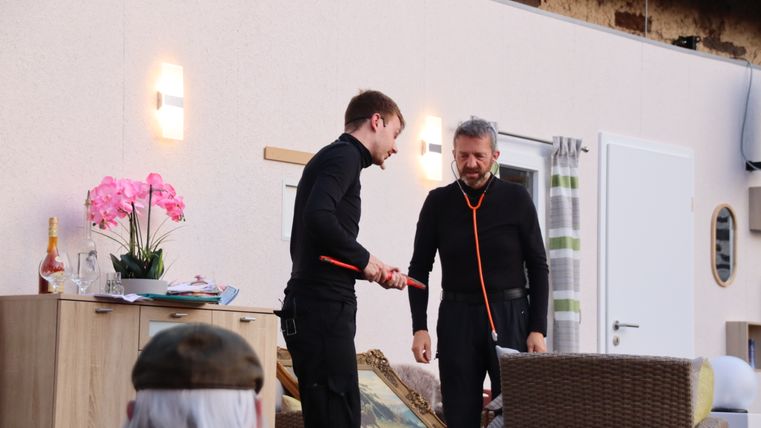 Zwei Schauspieler des Theatervereins Möntenich spielen eine Szene auf der Bühne und interagieren ausdrucksstark miteinander.