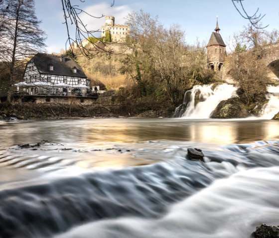 Die Pyrmonter M&uuml;hle am Traumpfad Pyrmonter Felsensteig mit Wasserfall und Burg im Hintergrund, umgeben von herbstlicher Natur., &copy; Eifel Tourismus GmbH, D. Ketz