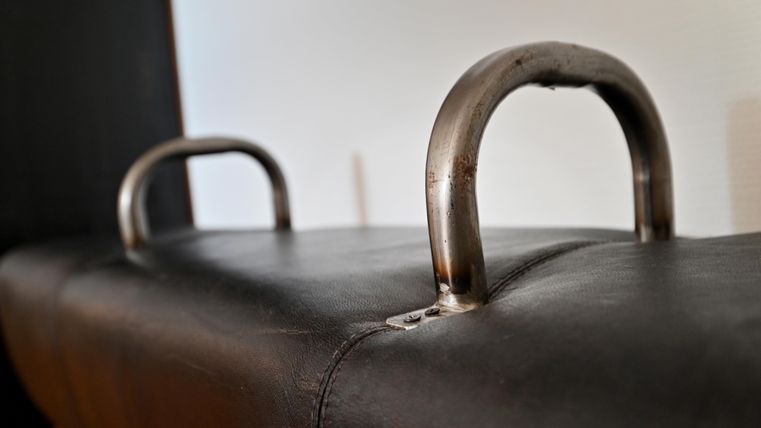 Ein schwarzer Bezug mit zwei Metallgriffen darauf. Der Hintergrund ist unscharf und hell.