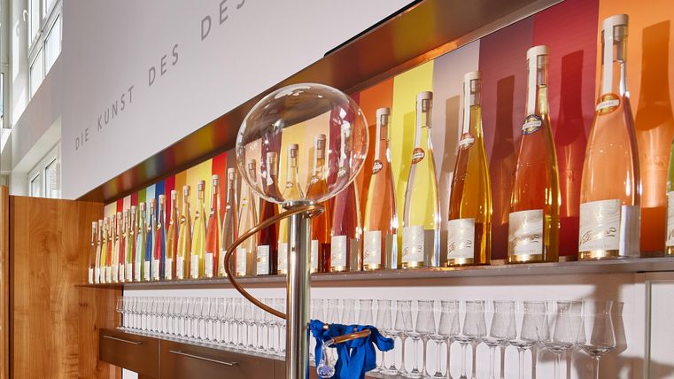 Een elegante bar met een verscheidenheid aan flessen in kleurrijke kleuren. Voor staan glazen klaar om te serveren.