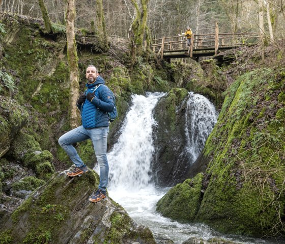 &Uuml;ber dem Wasserfall "die Rausch" f&uuml;hrt eine Holzbr&uuml;cke durch die bewaldete Schlucht, w&auml;hrend das Wasser kraftvoll in die Tiefe st&uuml;rzt., &copy; Eifel Tourismus GmbH, Dominik Ketz