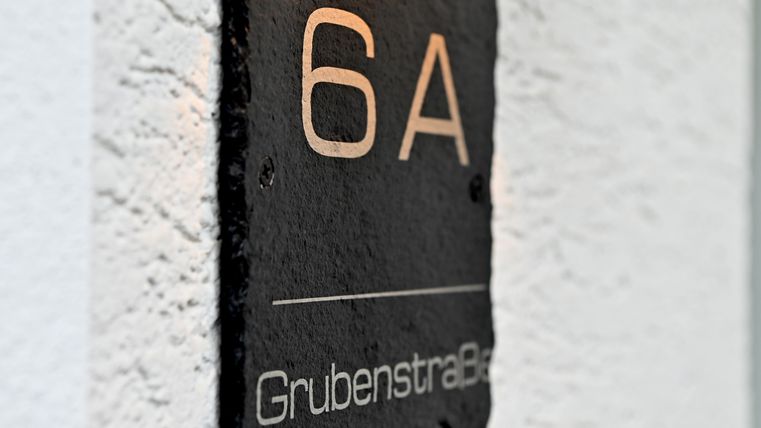 Die Hausnummer 6A ist auf einem schwarzen Schild aus Schiefer dargestellt. Darunter steht der Straßenname "Grubenstraße".