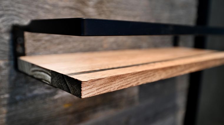 Ein modernes Holzregal, das an einer Wand befestigt ist. Die Oberfläche ist glatt und beleuchtet, mit einem minimalistischen Design.